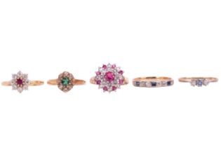 A collection of five gem set rings including a yellow metal three-stone bezel set diamond and