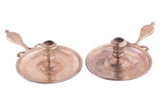 A pair of Regency silver chambersticks the round drip pans engraved with an eagle crest by Henry