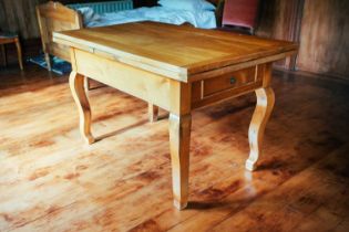 A Biedermeier fruitwood extending dining table, on square section cabriole legs, with pull-out ends,