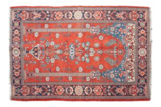 An old red ground Kashan rug with twin pillar and central flowering urn design, within an orn and