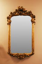 An 18th-century French giltwood wall mirror, 97 x 49 cm, the plate 67 cm x 36.5 cm, (re-gilt and