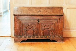 A 17th-century Continental oak coffer, with dentil moulding above two carved arcade facade on