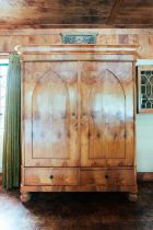 A large 19th century Biedermeier maple two door armoire, the moulded cornice over a pair of lancet