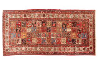 A large old Baktiari main carpet with a multi-section tiled field filled with flowers and