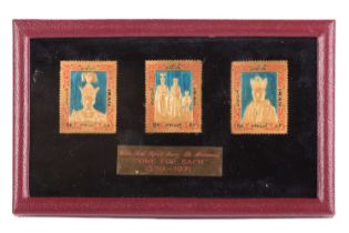 A set of three Iranian gold and enamel pictorial stamps, approximately 21ct gold, commemorating