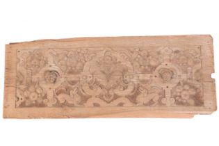 An early 17th-century carved oak frieze panel with strapwork, baying curs, fruit and cherubic heads,