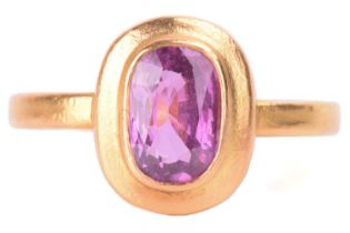 A purple sapphire solitaire ring, the oval mixed sapphire measuring approximately 9mm x 6mm and