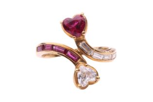 A ruby and diamond heart shape cross-over ring by Mouawad, featuring a heart shape diamond measuring