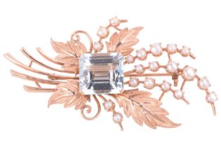 An aquamarine and pearl spray foliage brooch featuring a centred step-cut aquamarine measuring