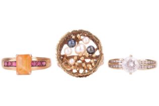 A collection of three rings, including a citrine ring with garnet set shoulders, the shank