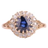 A sapphire and diamond set cluster ring. The mixed round cut sapphire measures approximatley 7.5mm x