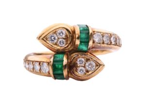 An emerald and diamond double serpent head ring, each snake head set with three round brilliant