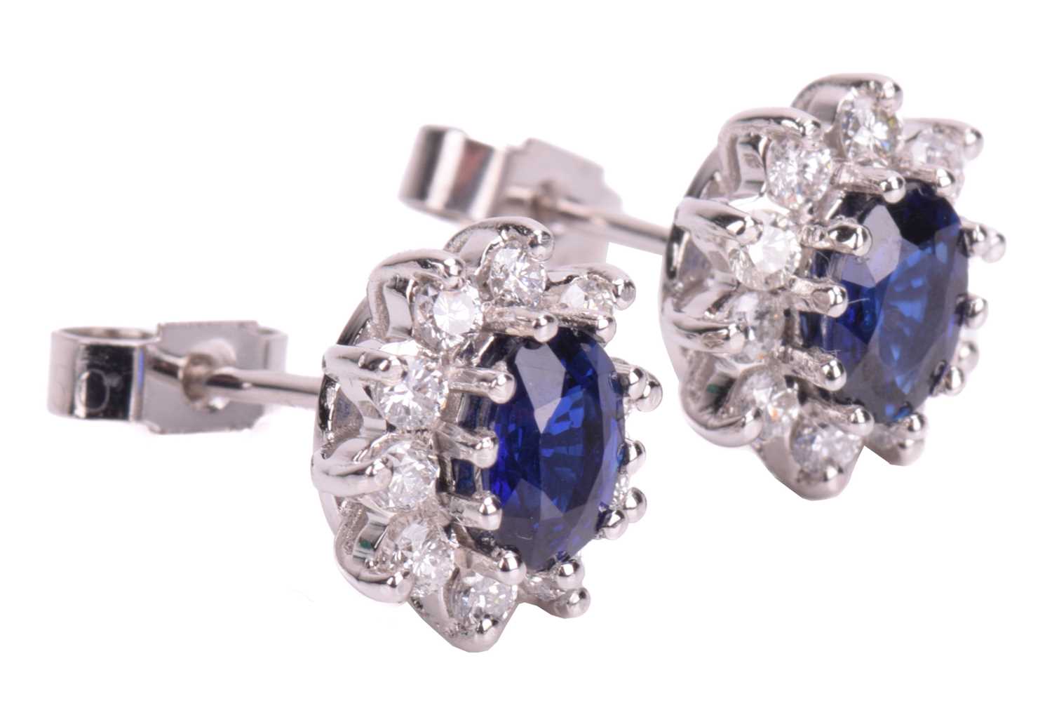 A pair of sapphire and diamond cluster earrings in 18ct white gold, each comprising an oval-cut - Image 2 of 3
