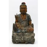 Sitzender Buddha auf Felssockel.