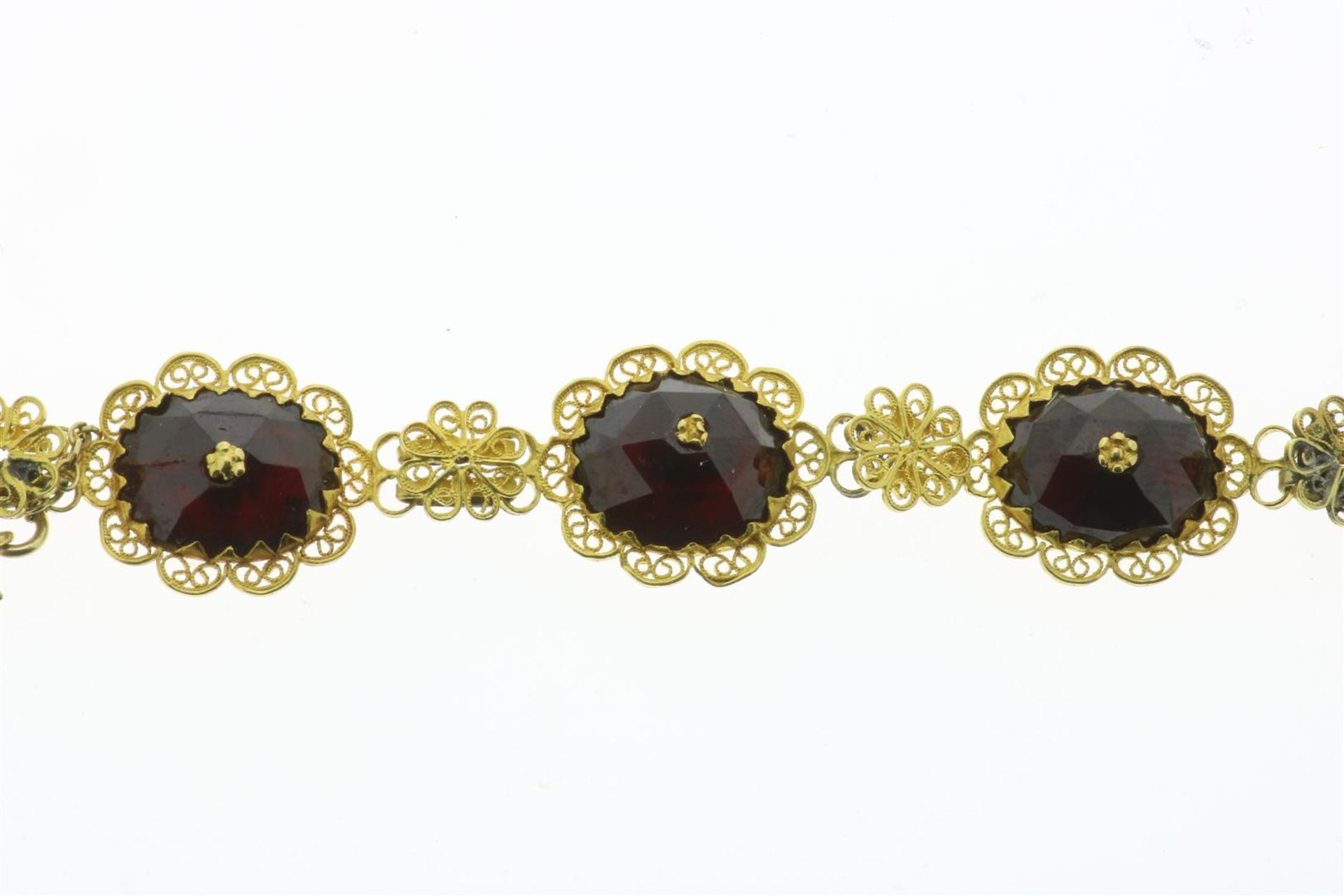 A gold boat necklace with garnets, a long necklace with drop-shaped garnets, 2 gold brooches with