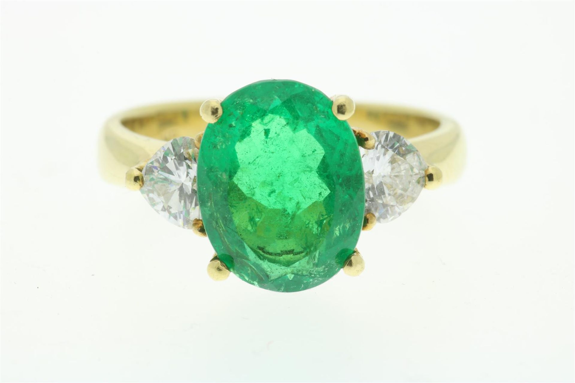 Yellow gold ring set with emerald, approx. 2.00 ct., and heart cut diamonds (measured set), alloy