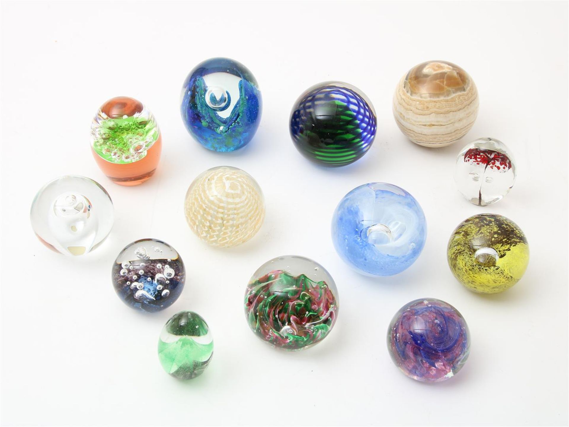 Series of 13 thick glass paperweights, with embedded bubbles and spiral decor, including: