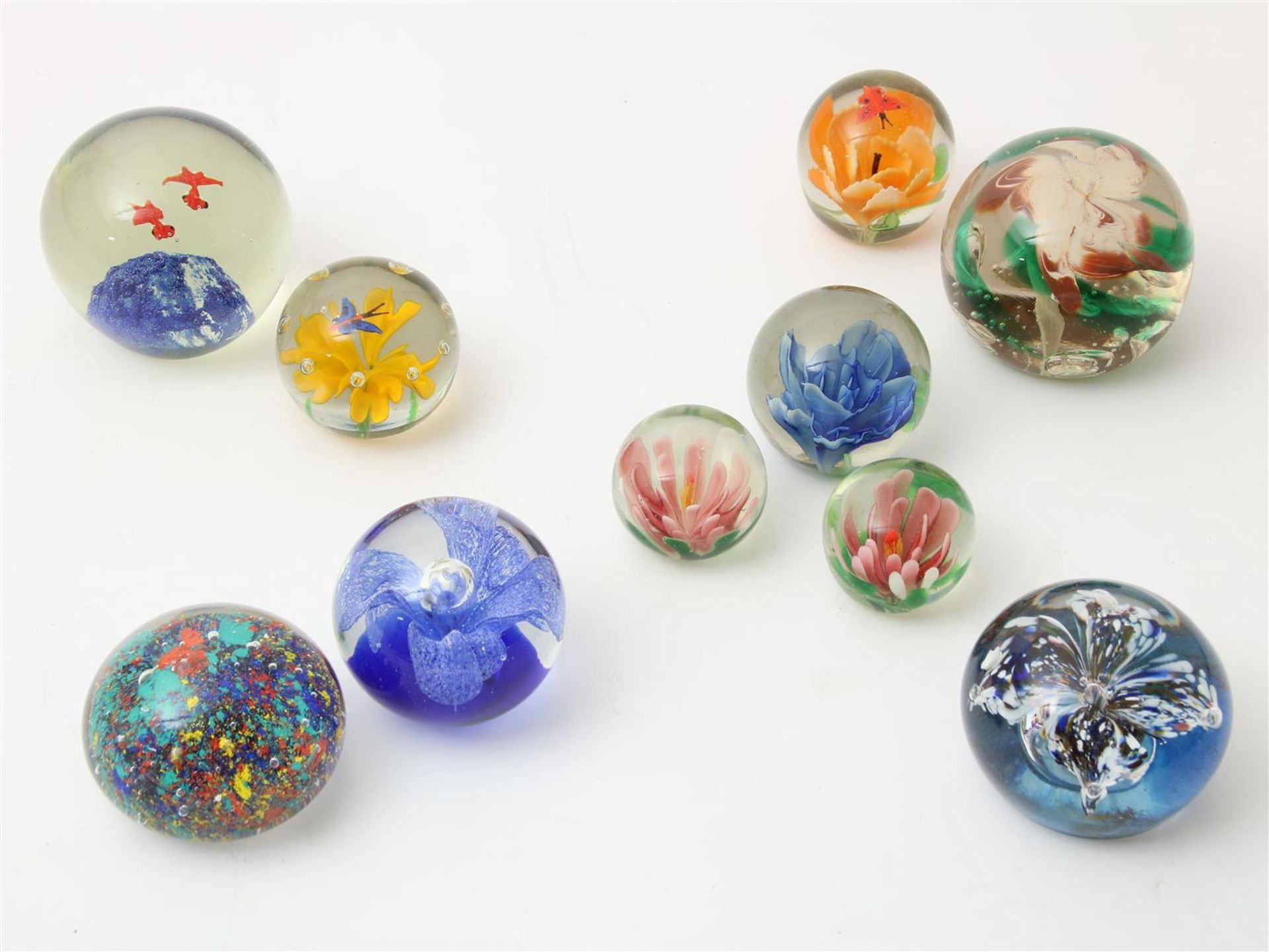 Series of 10 thick glass paperweights, with enclosed flower and fish decor, various sizes.