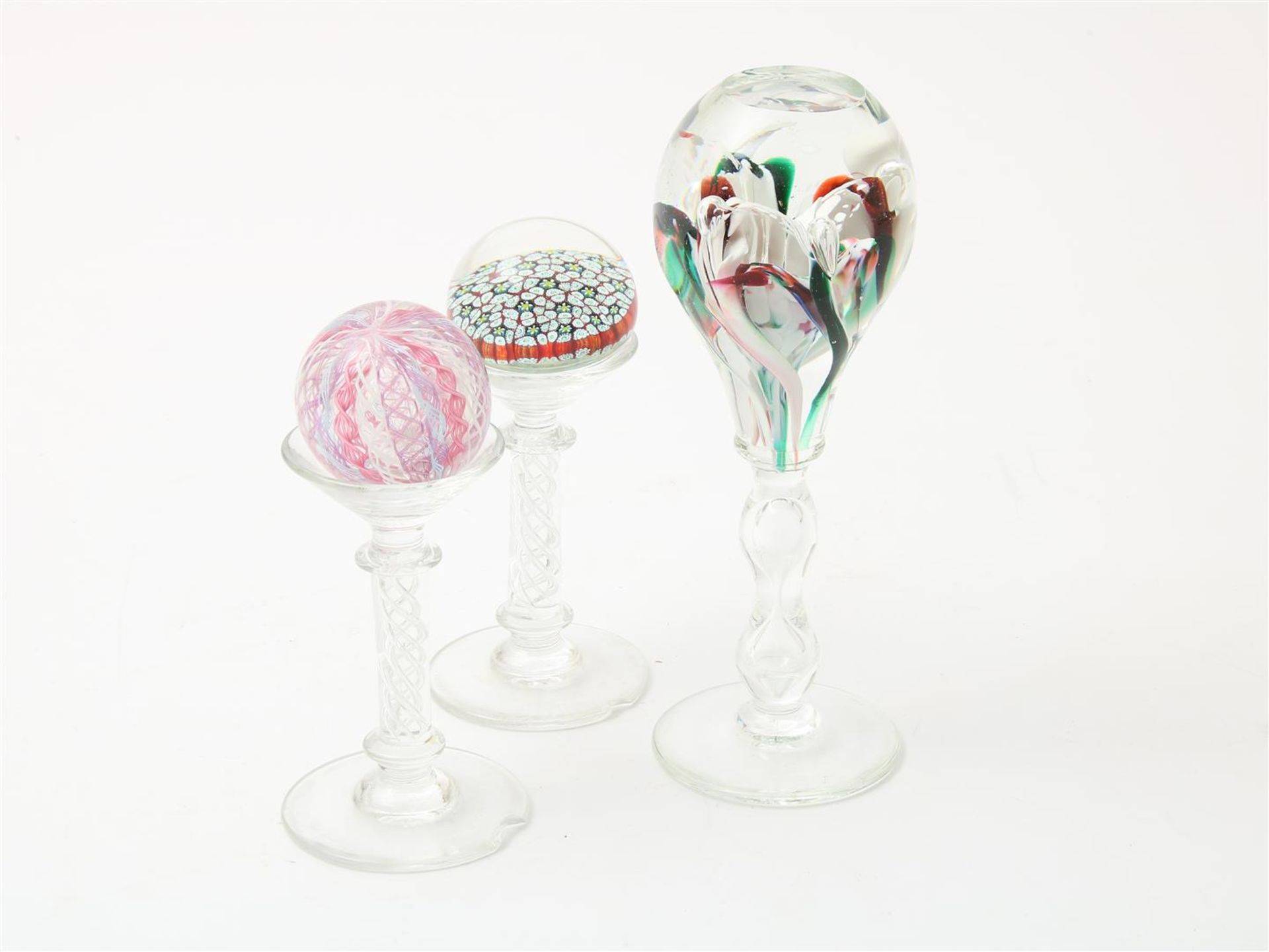 Series of 3 paperweights on raised base, with enclosed millefiori, flower and spiral decor, possibly