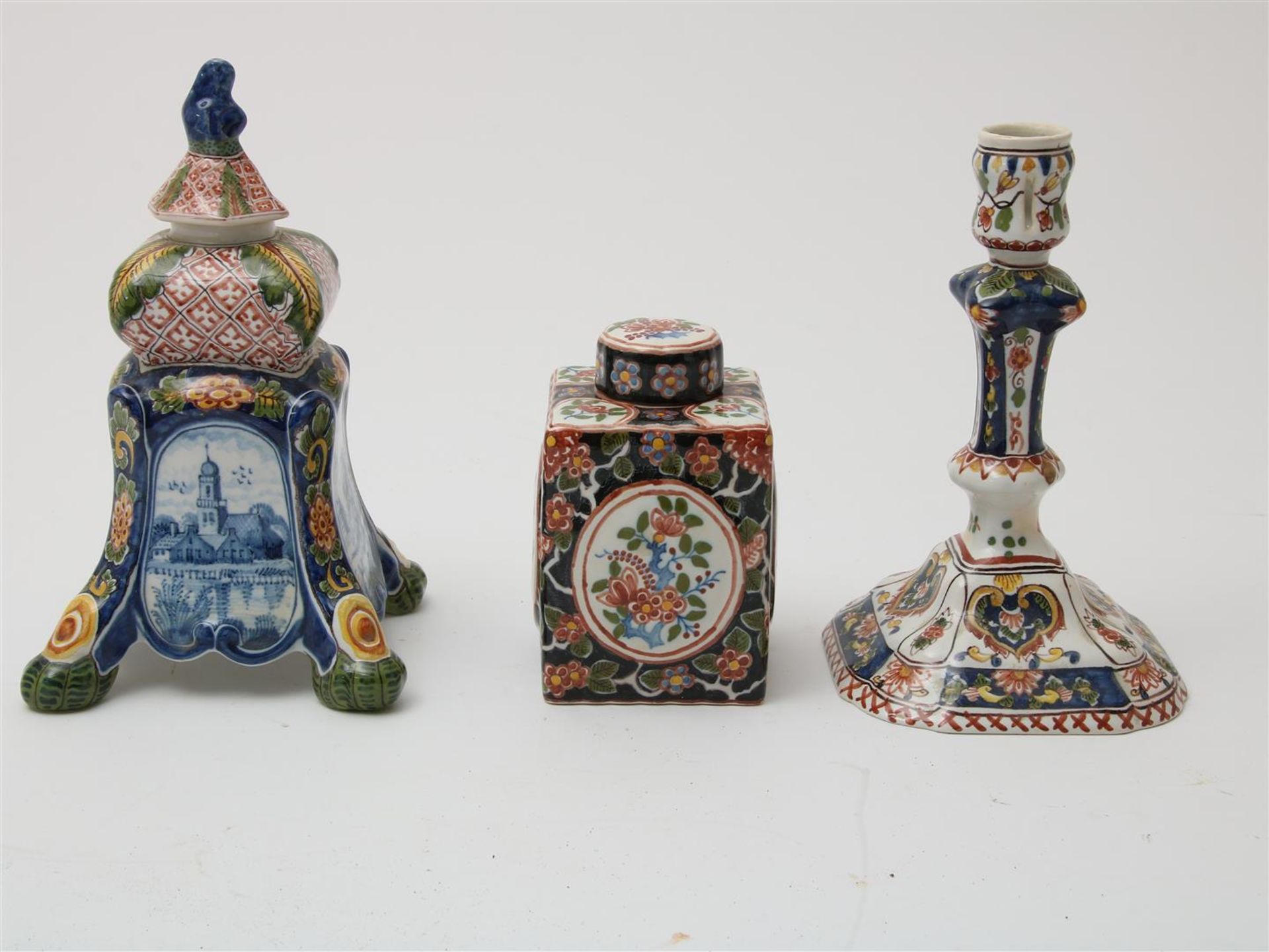 Lot of a polychrome earthenware candlestick, h. 21 cm., polychrome earthenware tea caddy, h. 13