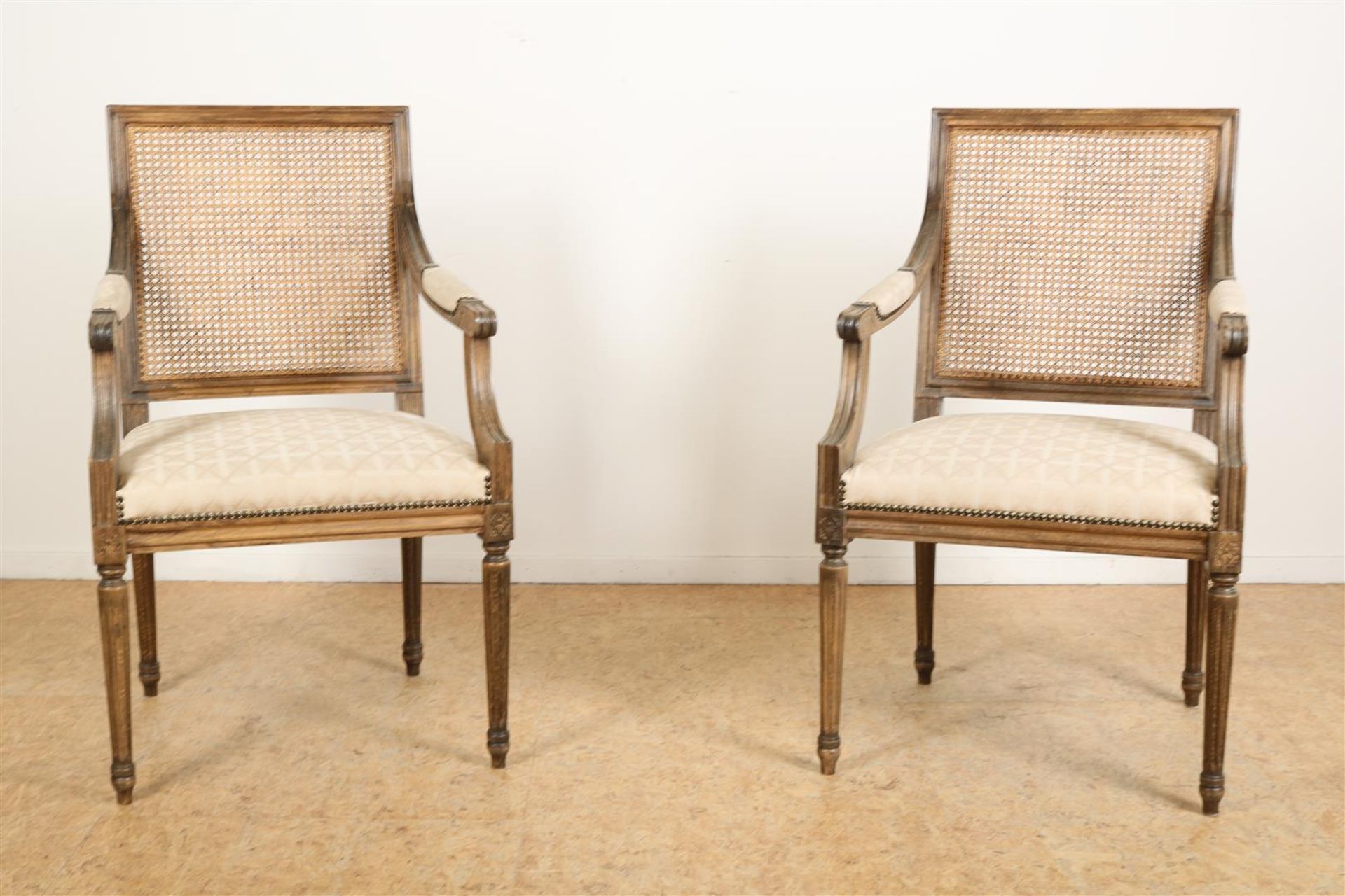 Set of Louis XVI style armchairs with woven backrest and checkered upholstery.
