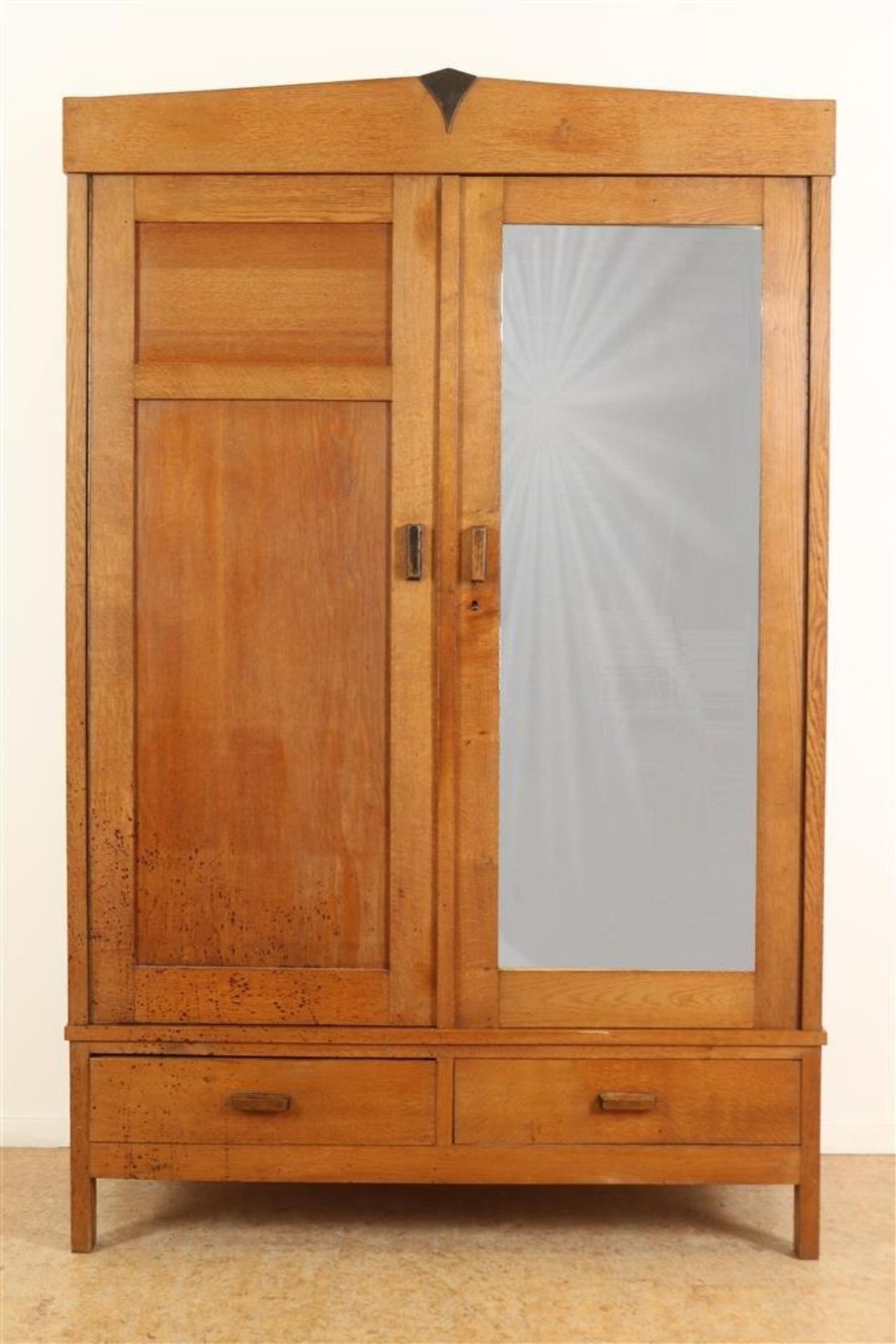 Oak Amsterdam School linen cupboard with cut mirror and panel door and drawer, ca. 1925, h. 203,