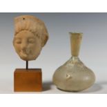 Roman glass bottle, ca. 2nd century AD and an Etruscan terracotta part of a portret mask, ca. 500 BC