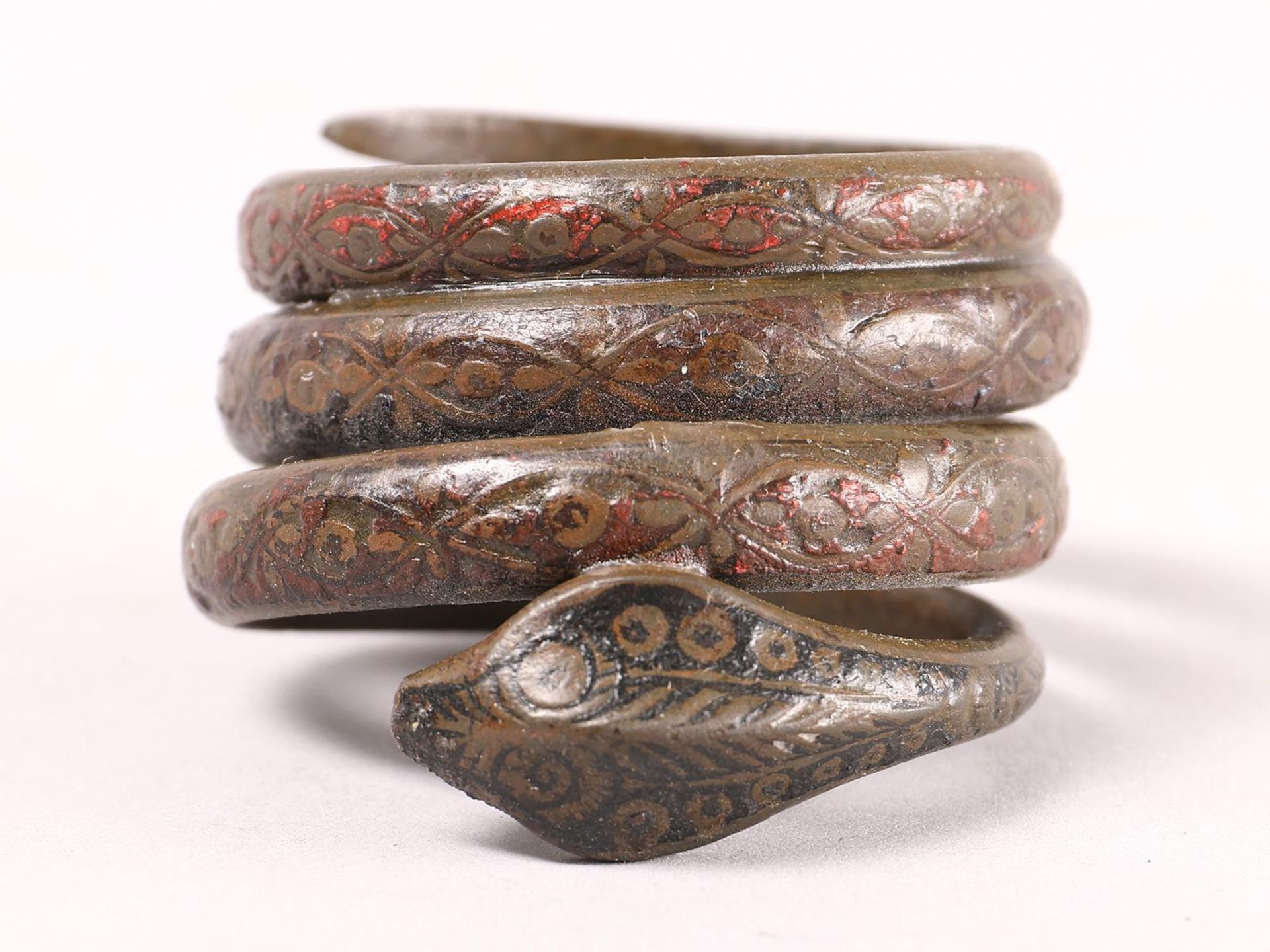 A antique coiled bronze snake armlet,