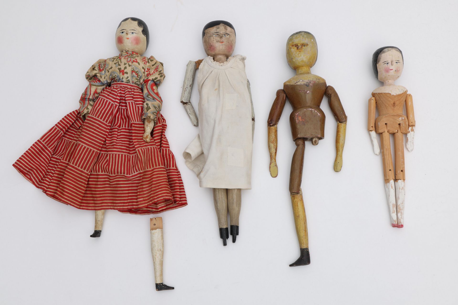 Vier houten poppen, zgn. Dutch dolls, 19e eeuw; het linkerbeen is aanwezig, maar staat niet op de fo
