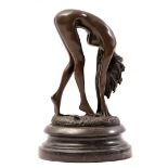 Bronze sculpture of a bent nude