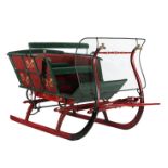 Green and red lacquered wooden and metal sleigh with upholstery