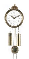 Round brass wall clock with enamelled dial