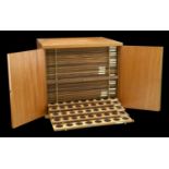 A mahogany coin cabinet by Swann, 40 x 34 x 35.5cm, comprising 30 trays double-pierced to ho...