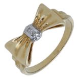 A diamond set bow ring, realistically modelled, the polished bow centred with two diamond po...
