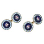 A pair of enamelled cufflinks, each of the circular panels comprising an enamel floral scene...