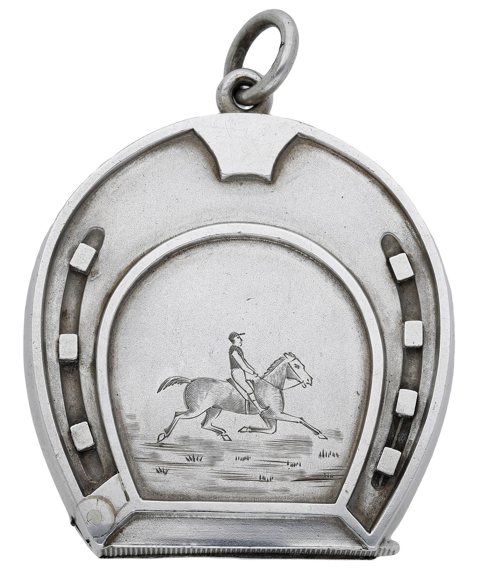 A Victorian silver horseshoe-shaped vesta case, the front engraved with a horse and rider, m...