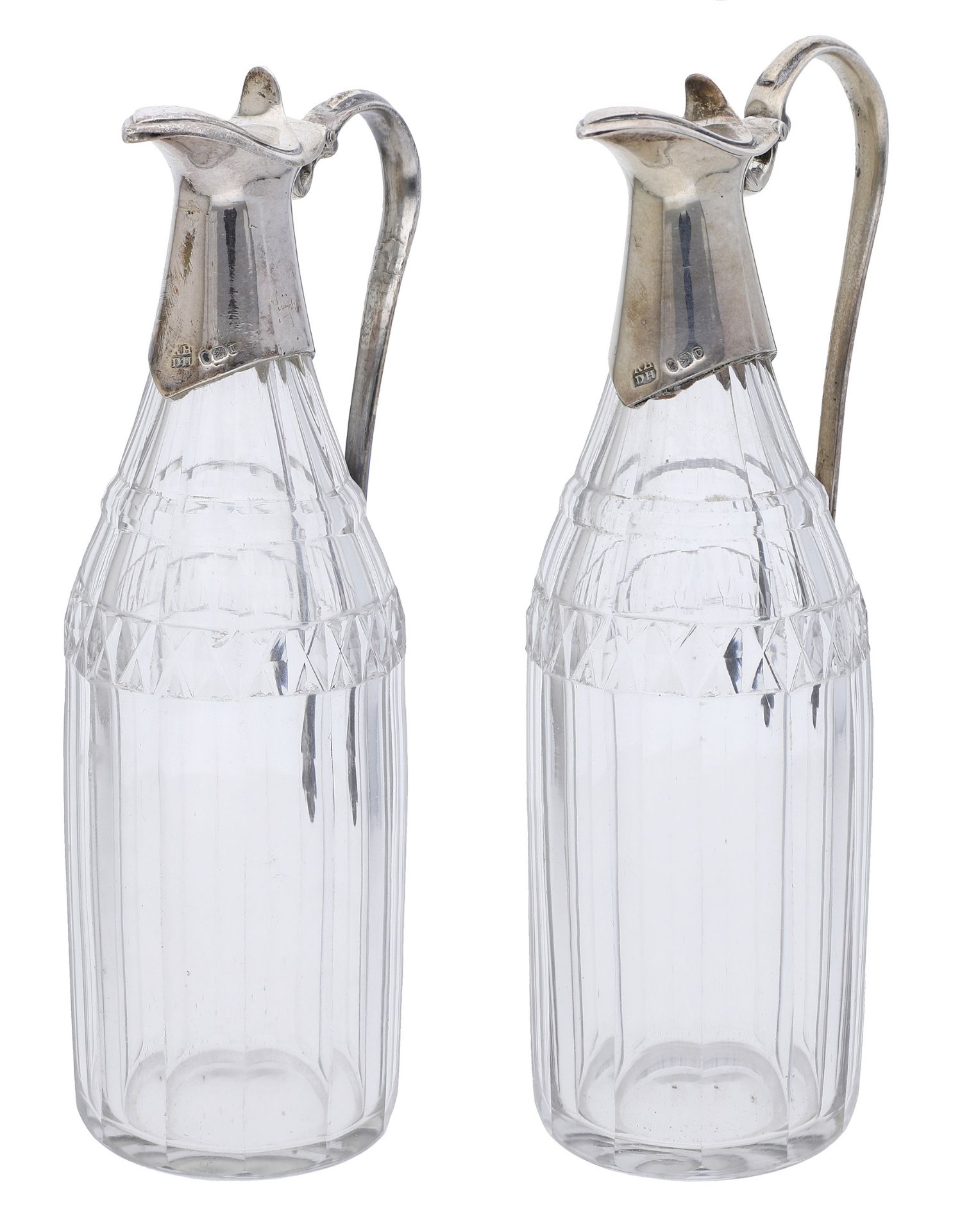 A pair of George III cruet bottles, with faceted glass bodies, the silver mounts with moulde...