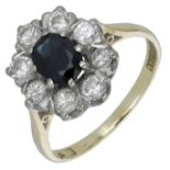 A sapphire and diamond cluster ring, set with an oval-cut sapphire within a surround of bril...