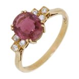 An 18ct gold pink tourmaline and diamond ring, the oval mixed-cut tourmaline claw-set betwee...