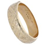 A 9ct gold hinged bangle, of hollow form, with engraved foliate and scroll decoration throug...