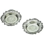 A pair of Victoria silver wine coasters, the broad, scroll-pierced borders with 'C' & 'S' sc...