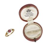 A mid 19th century ruby and pearl three stone ring, the oval-cut ruby set between two seed p...