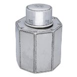 A George V silver octagonal tea caddy with pull off cover, with lightly planished, feather e...