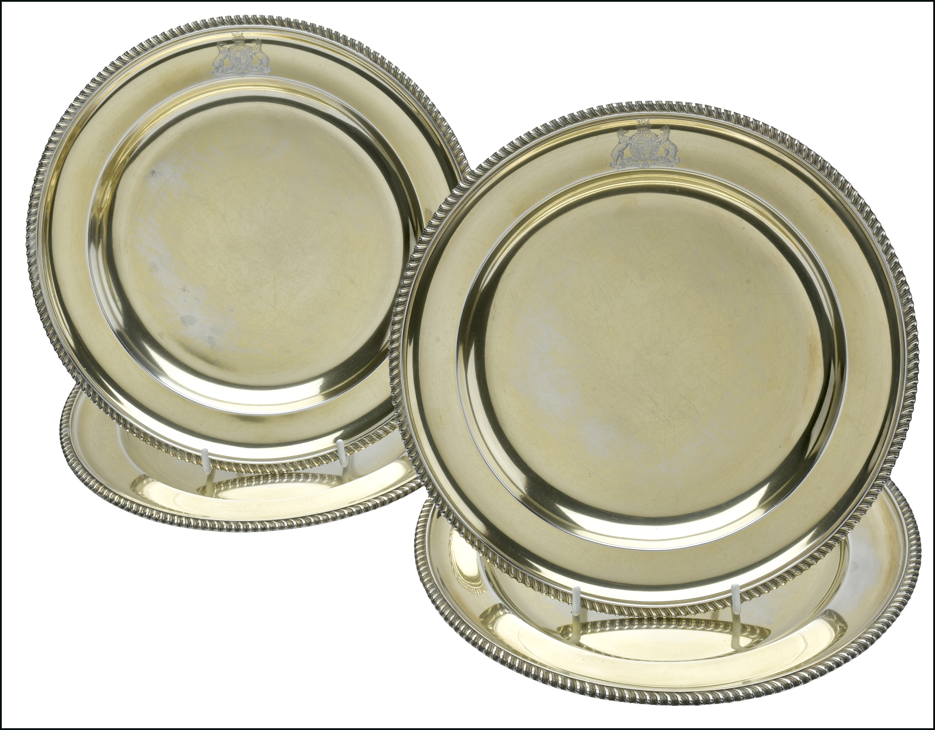 A set of four Victorian silver gilt Dinner Plates, with gadrooned rims, each engraved with t...