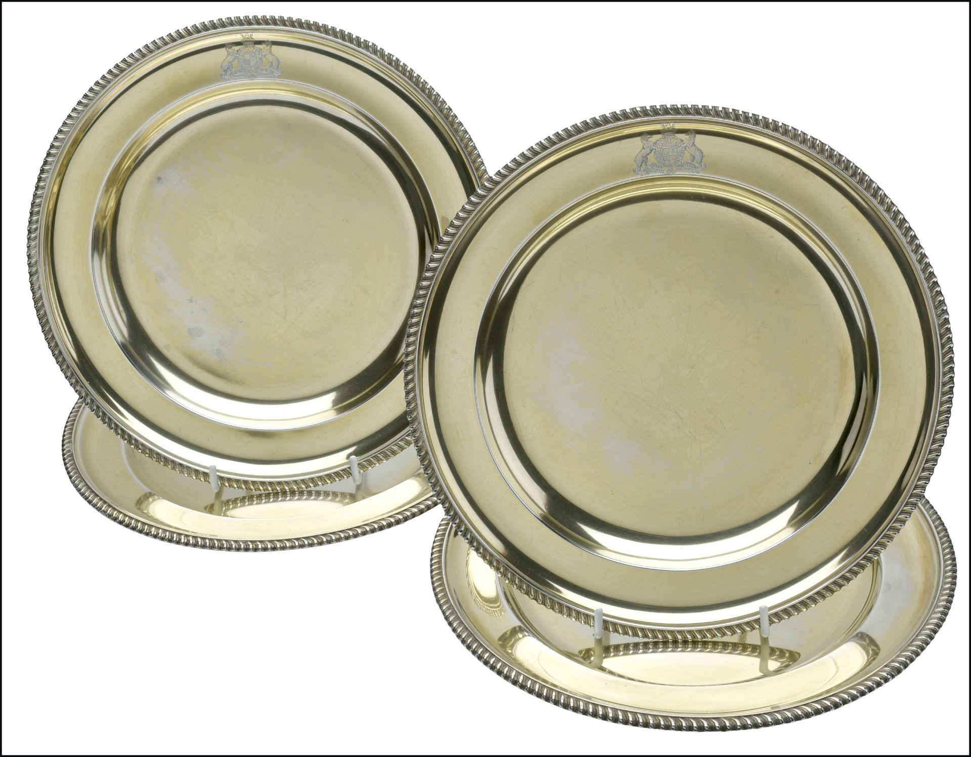 A set of four Victorian silver gilt Dinner Plates, with gadrooned rims, each engraved with t...