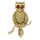 An 18ct gold owl brooch by KERN, the owl realistically modelled, and seated on a branch, wit...