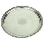 A George III silver salver, with gadrooned border, on three gadroon-edged feet, centred with...