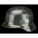 A Second War German M35 steel helmet. A Second War German M35 steel helmet, repainted in bl...