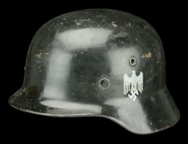 A Second War German M35 steel helmet. A Second War German M35 steel helmet, repainted in bl...