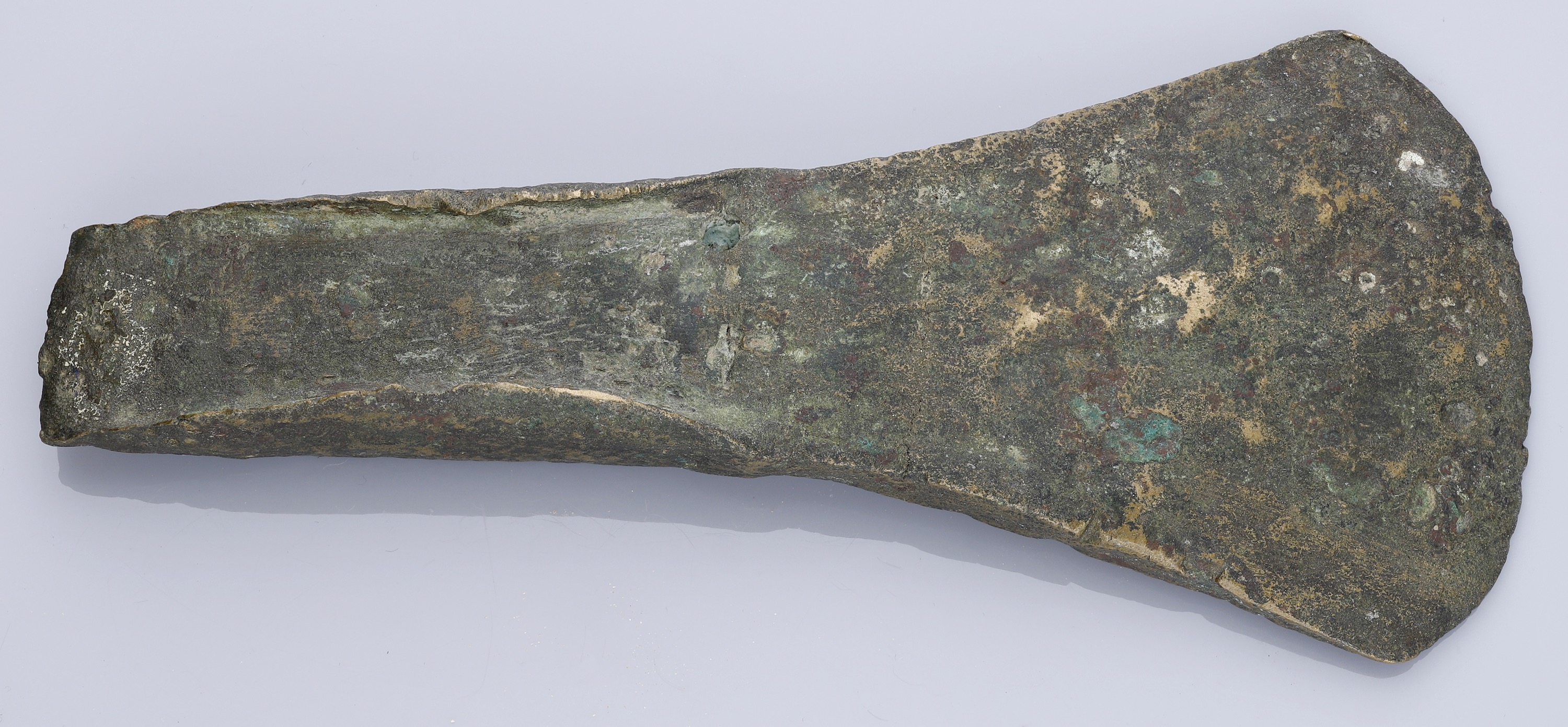 Bronze Age, a flat axe with side flanges, c. 1800-1500 BC, 15.5cm long by 7cm wide by 2cm de...